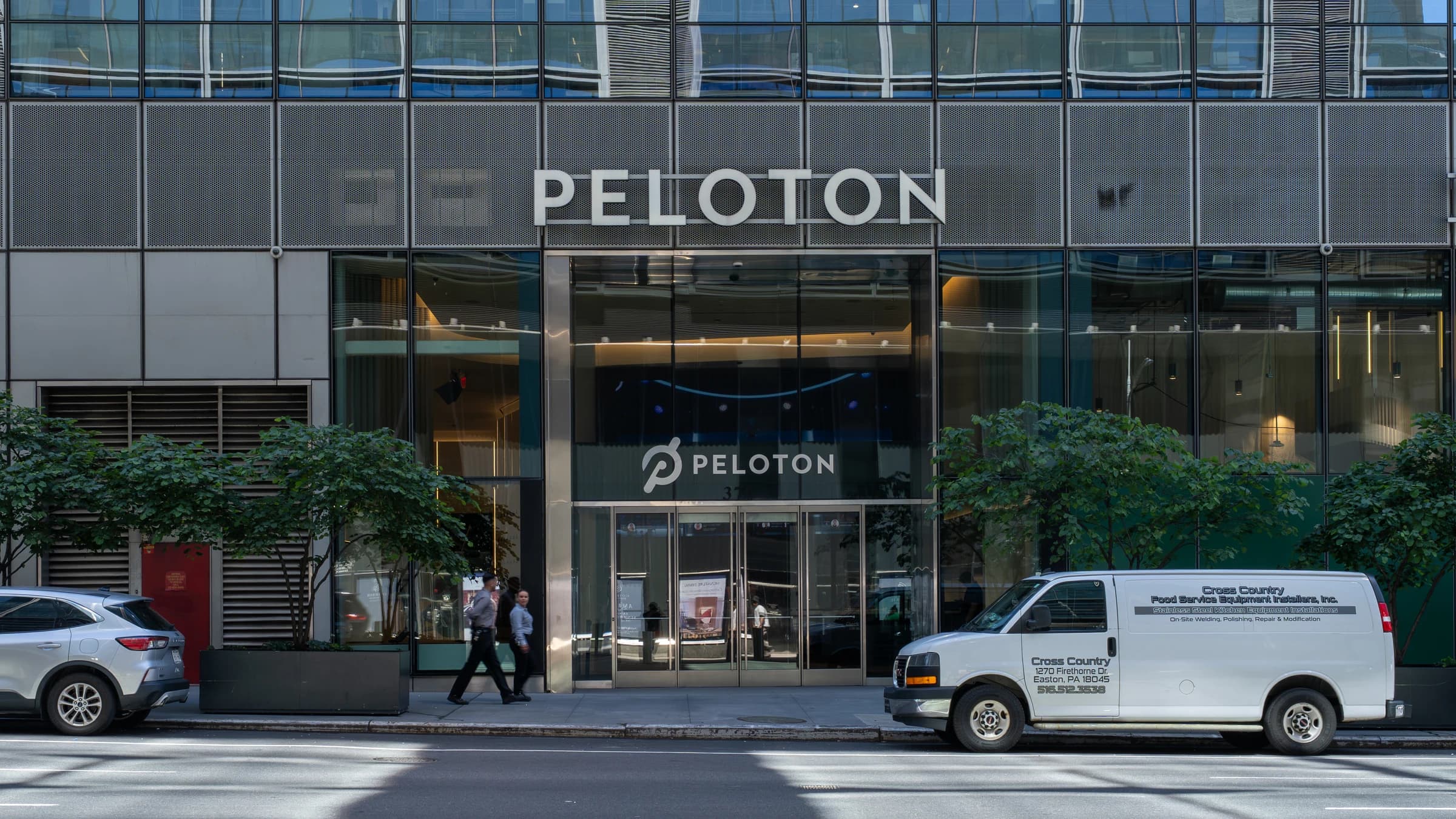 The glass and steel street front of Peloton Studios in New York, with the Peloton name above the entrance.